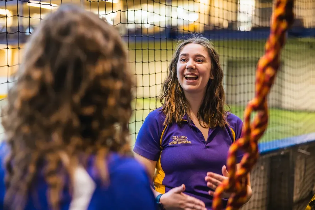 Climbing wall instructor talks with students about to climb